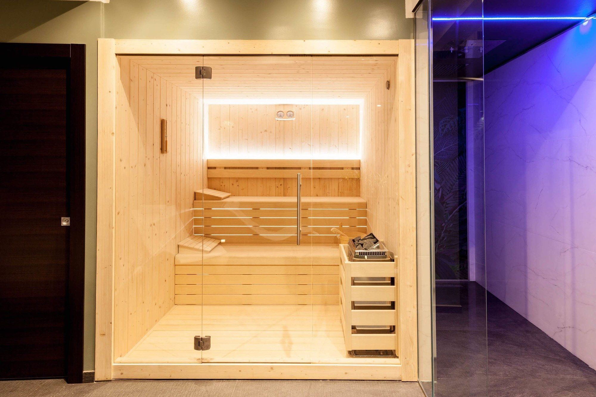 La cabina della sauna in legno, vista dalla zona relax