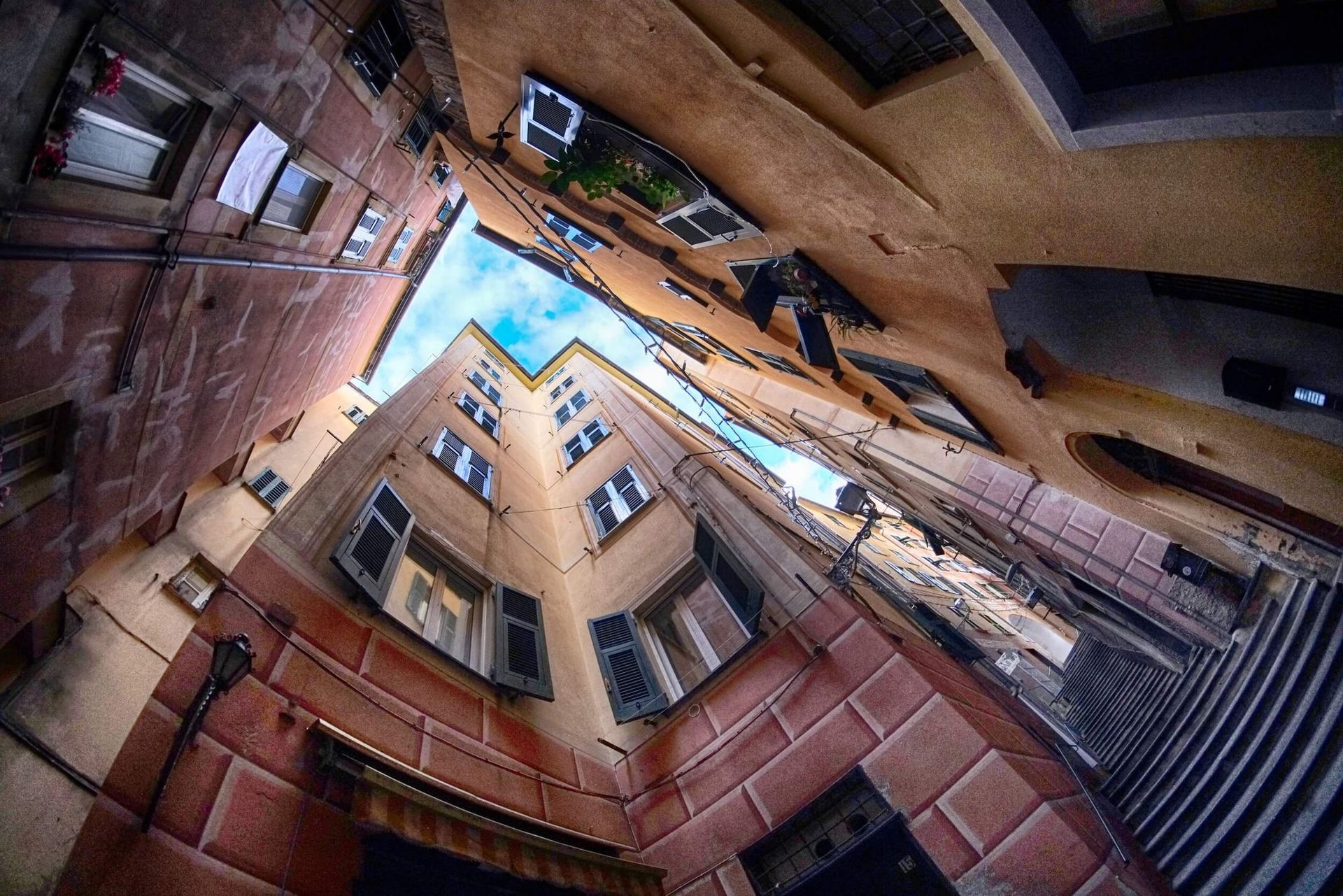 I palazzi dei caruggi visti dal basso, con la striscia di cielo del centro storico di Genova